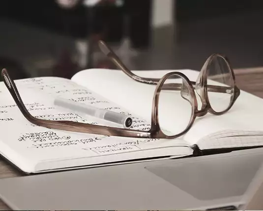 Eine Brille liegt auf einem Notizbuch